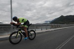 triathlonatlet som cyklar på morgonträning foto