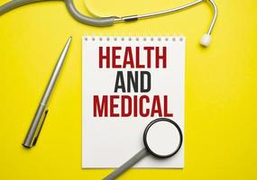 hälsa och medicinsk ord på anteckningsblock och stetoskop foto