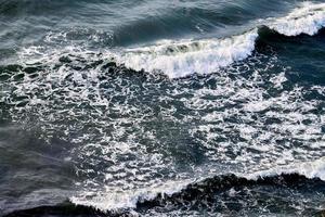 djup blå hav vattnen stänk med skummig vågor, mörk blå vågig hav vatten yta, stormig hav foto