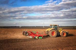 de traktor förbereder de jord för sådd och odling. lantbruk och agronomi begrepp. foto