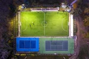 antenn se från Drönare av en skön parkera med ett utomhus- fotboll och tennis lekplats foto