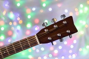 de nacke av de akustisk gitarr på jul ljus bokeh bakgrund foto