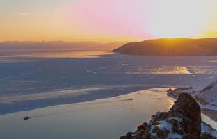 skön scen av sjö baikal i vinter- med kväll solnedgång ljus. foto