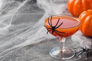färsk pumpa juice. begrepp halloween firande. bakgrund av Spindel webb. foto