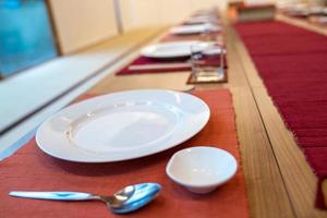 japansk modern applicerad matsalsstil med östlig maträtt, gaffel, sked, servett och glas på bordet. foto