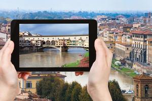 turist fotografier ponte vecchio i florens foto