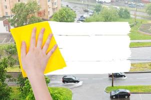 hand raderar regn på gata förbi gul trasa foto