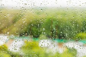 regn droppar på fönster glas i sommar dag foto