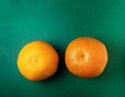 två mogen mandariner på en grön bakgrund foto