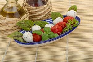 caprese sallad i en skål på trä- bakgrund foto