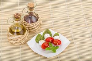 caprese sallad på tallriken och trä bakgrund foto