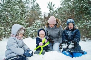 mamma med tre barn i vinternatur. utomhus i snö. foto