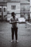 porträtt av sorglös stilig ung man är känsla fri under de regn foto