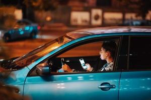 förlorat kvinna förare använder sig av mobil telefon medan körning på natt. foto