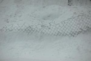 blog i snö. snö pank staket. textur snö lavin. foto