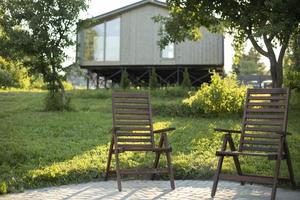 stolar i bakgrund av hus. trä- stolar för avslappning. territorium med hus. foto