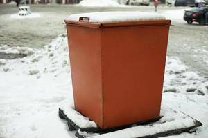 stål tank. soptunna. plats till Lagra sand på motorväg. orange objekt i vinter- på väg. foto