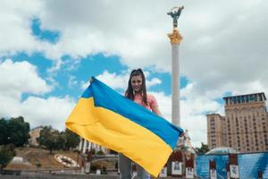 ung kvinna med nationell flagga av ukraina på de gata foto