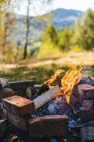 camping öppen bål brinnande i cirkel av stenar. foto