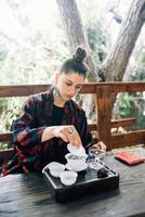bearbeta bryggning te. kvinna stöpning ört- te foto