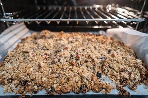 granola till laga mat i ett elektrisk ugn. begrepp av enkel Ingredienser för friska frukost foto