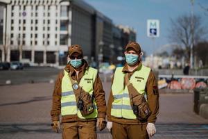 kiev, Ukraina, Mars 28, 2020, två polis kommenderar på ansiktsbehandling skyddande masker på nästan tömma gata, karantän tid på Ukraina, foto