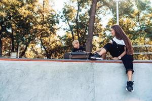 skön ung hipster mamma och liten son på de skatepark foto