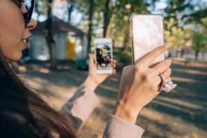 skön ung flicka innehar i henne händer två smartphones foto