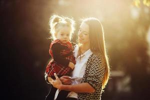 mor och liten dotter spelar i en parkera foto