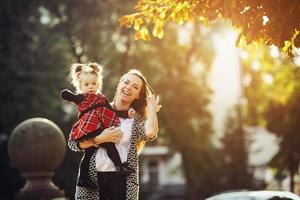 mor och liten dotter spelar i en parkera foto