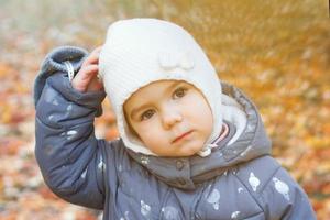 porträtt av liten caucasian flicka på bakgrund av höst löv. foto