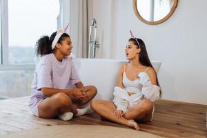 två flickor talande på de badrum golv foto