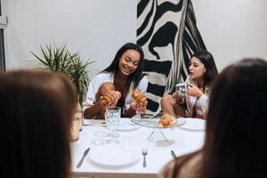 grupp kvinnliga vänner som njuter av måltiden hemma foto