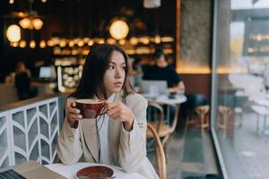 ung lady bläddring de internet på de Kafé foto