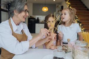 mormor och barnbarn är matlagning på kök. foto