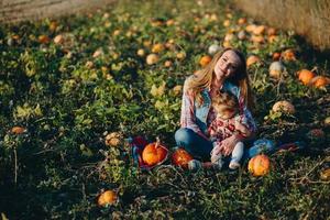 mor och dotter på en fält med pumpor foto