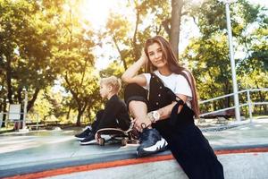 skön ung hipster mamma och liten son på de skatepark foto