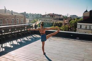 ung kvinna praktiserande yoga på de tak av en byggnad foto