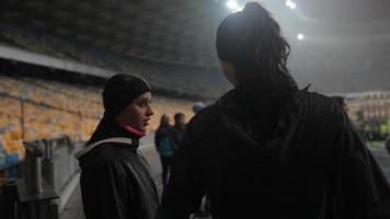 människor gå i för sporter på natt stadion i regnig väder foto