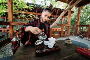 de te ceremoni. kvinna häller vatten i en te skål. foto
