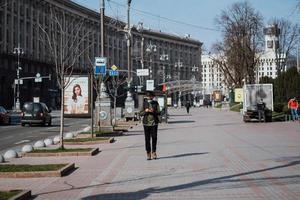 kiev, Ukraina, Mars 28, 2020, ukrainska människor på ansiktsbehandling skyddande masker på nästan tömma gata, karantän tid på Ukraina, foto