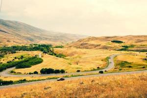 bil kör i landsbygden serpentin väg utomhus i natur med naturskön bergen panorama. resa väg resa i kaukasus- armenia foto