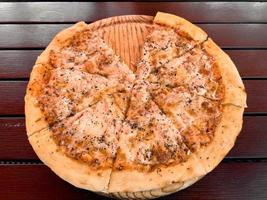 bitar av pizza på en trä- bricka. foto