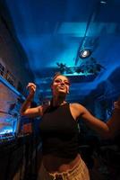 skön kvinna dj dans till techno i en små klubb foto