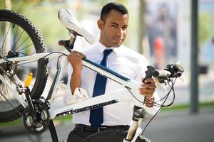 stilig kontorsanställd som bär sin trasiga cykel