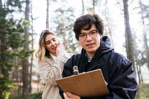 vetenskapsmän är studerar växt arter och inspektera träd i de skog. foto