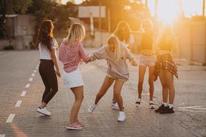 sex ung kvinnor dansa i en bil parkera foto