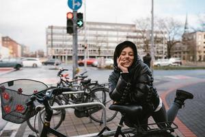 ung kvinna Framställ i en parkering massa med cyklar foto