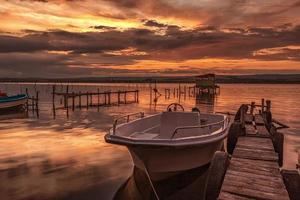 humör och lugn på en sjö Strand med en båt på en trä- pir foto