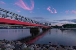 de kulturell bro - en tåg och fotgängare bro i aalborg, Danmark, under en färgrik solnedgång foto